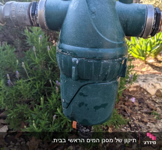 מסנן מים ירוק עם חיבורים מתכתיים בגינה